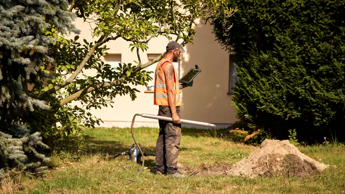 Techniker arbeitet im Garten am Glasfaseranschluss.